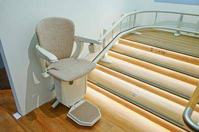 Beige chair of stairlift with curve at the top of the stairlift