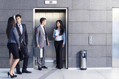 Four people stand in front of open lift